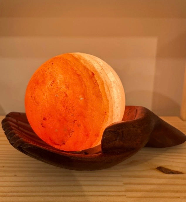 Sfera di sale Hymalaiano su mano in legno